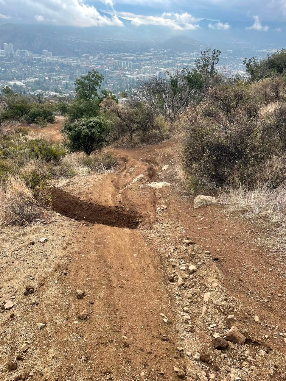 Curva peraltada recién construida, con Santiago y la cordillera al fondo